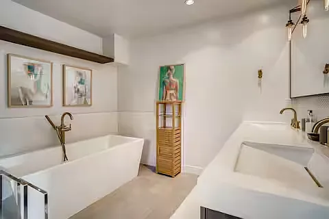 View into the master bathroom on the right, with a large soaking tub and dual vanity