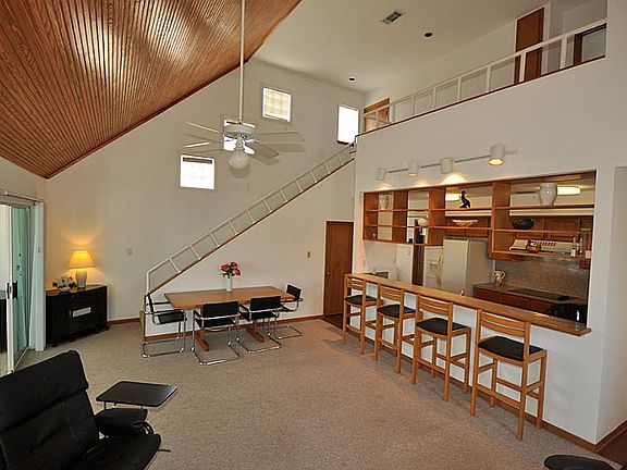 Living, dining with soaring ceilings and oak bead board ceiling treatment.