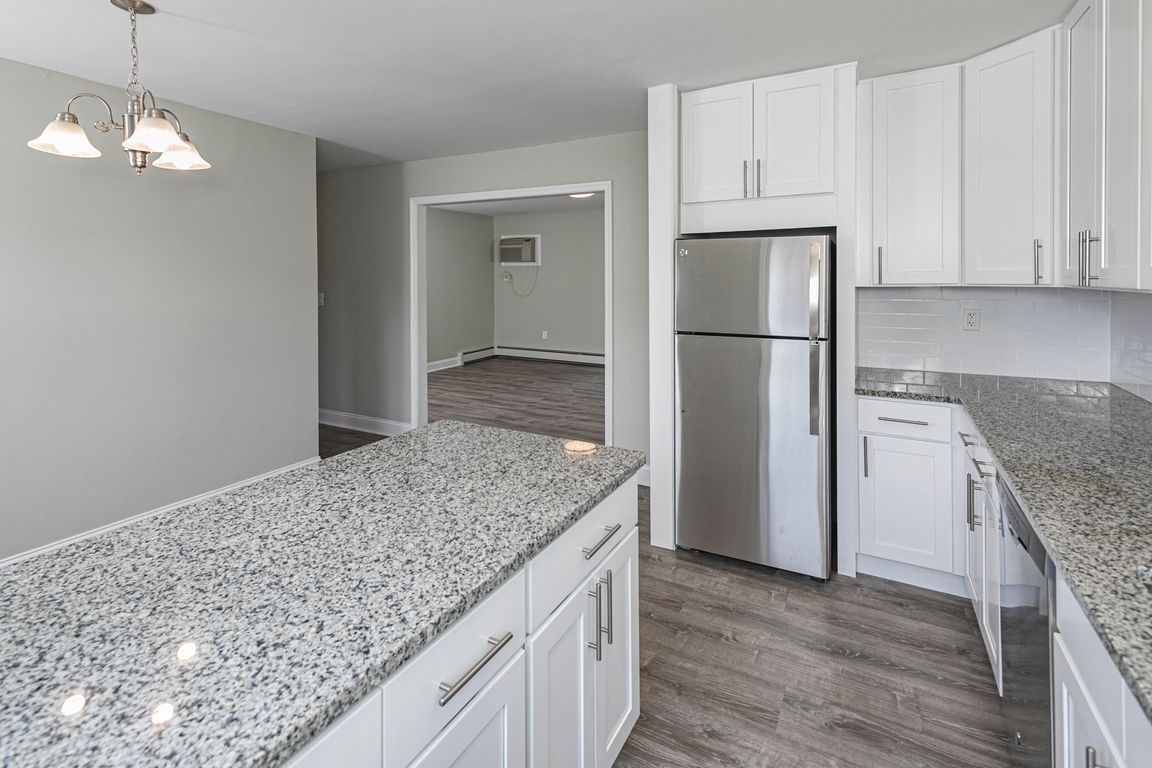 Newly renovated kitchen with white cabinets and granite countertops