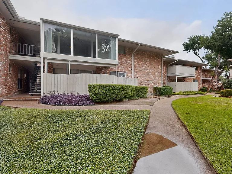 The condo exterior with a well-maintained yard