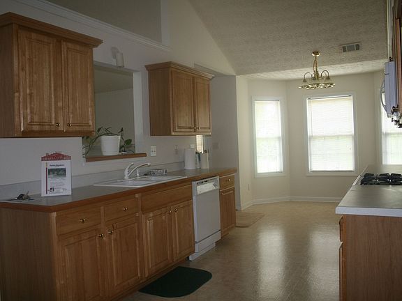 Kitchen has breakfast area overlooking wooded backyard view