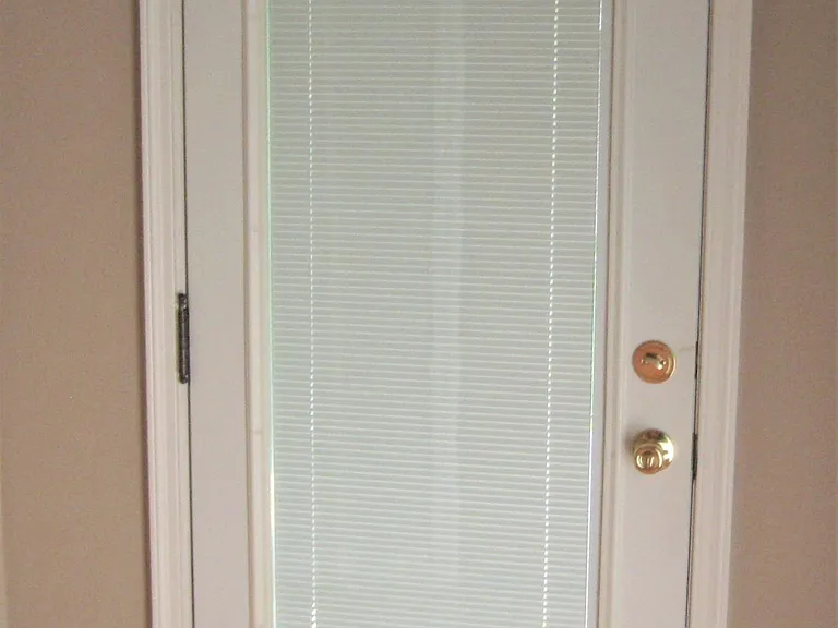 Foyer door with interior blinds for stepping onto petite side front porch. Morning coffee? Afternoon Tea? Relax and watch the "Retro 50's" traffic roll on by?