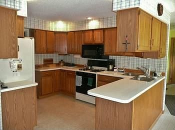 Nice wood cabinets adorn this beautiful kitchen with newer Corian counters!