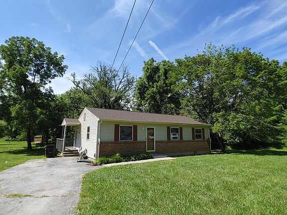 Front: large yard, paved drive, few steps, single story.