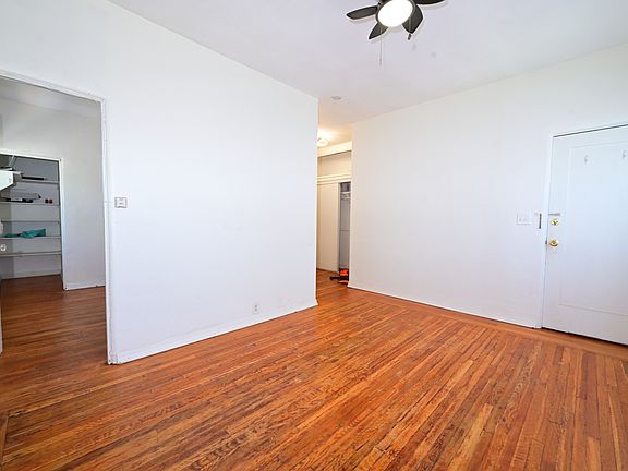BRIGHT and charming living room (high ceiling and refinished original hardwood floor), windows A/C and ceiling fans