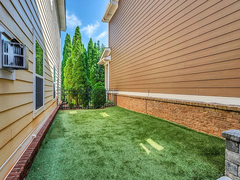 Side yard includes a fenced grass area next to patio