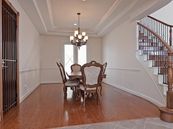 Finely appointed, the formal dining room touts a double tray ceiling with ambient lighting, chair rail moulding, hardwoods, recessed lighting & chandelier, and wrought iron encased wine storage. Through the atrium doors is a 13' x 11' terrace.