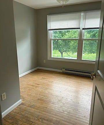 Sunny & airy bedroom, with thermal pane windows and ceiling fan.