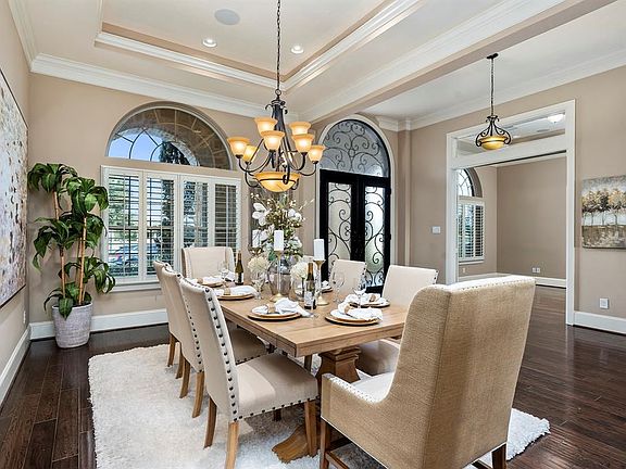 The formal dining is flanked by the study and wine room. Many rooms throughout the home, including this one, feature dimmable lighting to create the perfect atmosphere.