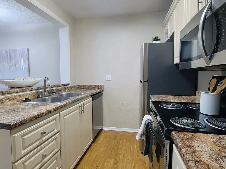 Kitchen love, where open-concept living begins with granite-style countertops and gleaming stainless allure.
