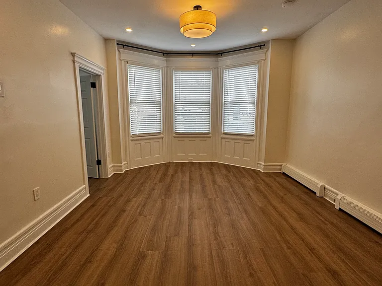 Living Room (Actual Room): Spacious, open-concept living area with abundant natural light and a charming bay window_perfect for relaxing or entertaining