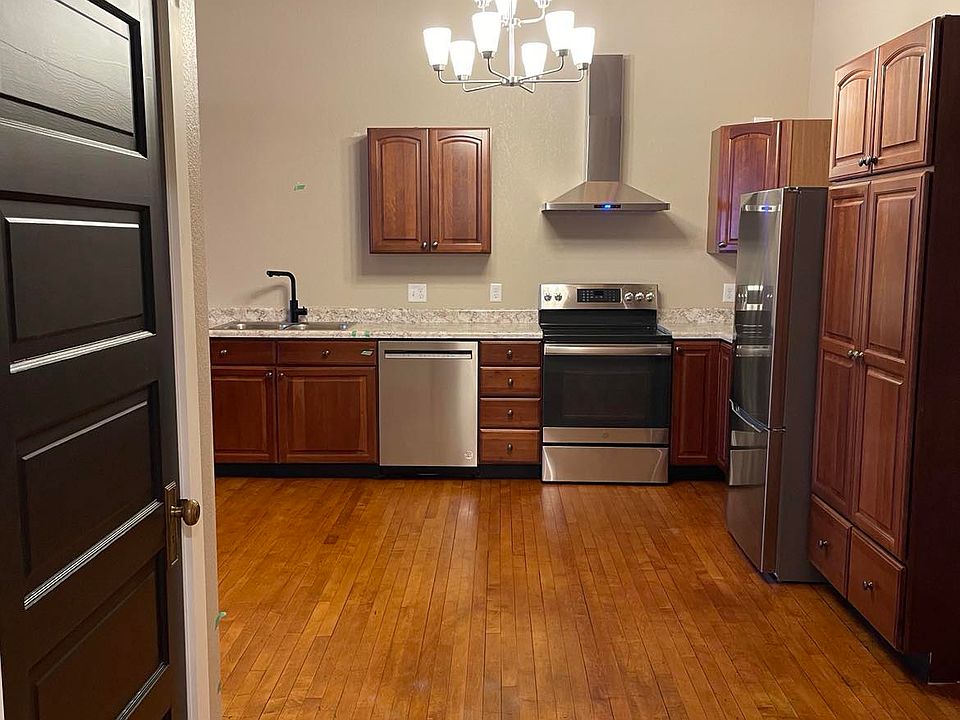 This view is coming out of the bathroom. Entry door is on the right in this photo. Black door on left is the coat closet. Also gives you another view of the kitchen.