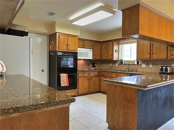 Wow! A cook's dream kitchen..granite counter tops, double ovens and easy access to both den and formal dining!