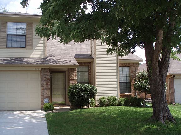 Front of house with large tree in yard