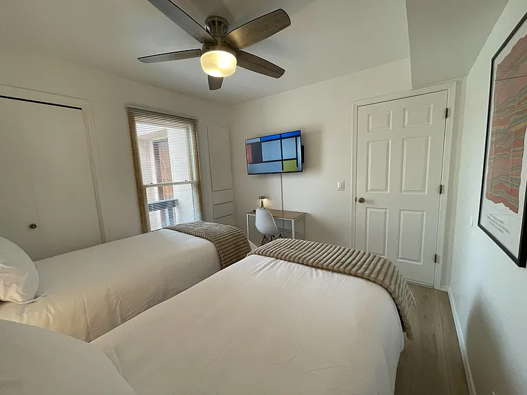 Upstairs bedroom in 2 twin XL configuration with workspace, Roku TV, closet, and built-in storage that is perfect for clothes that do not need hanging.
