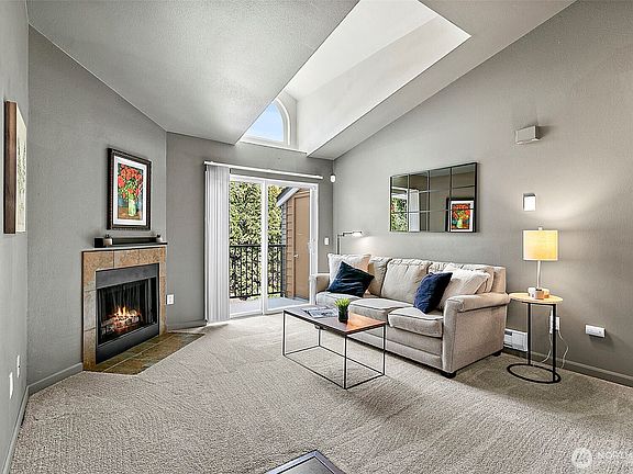 Light and bright living space with a skylight and cozy wood burning fireplace>