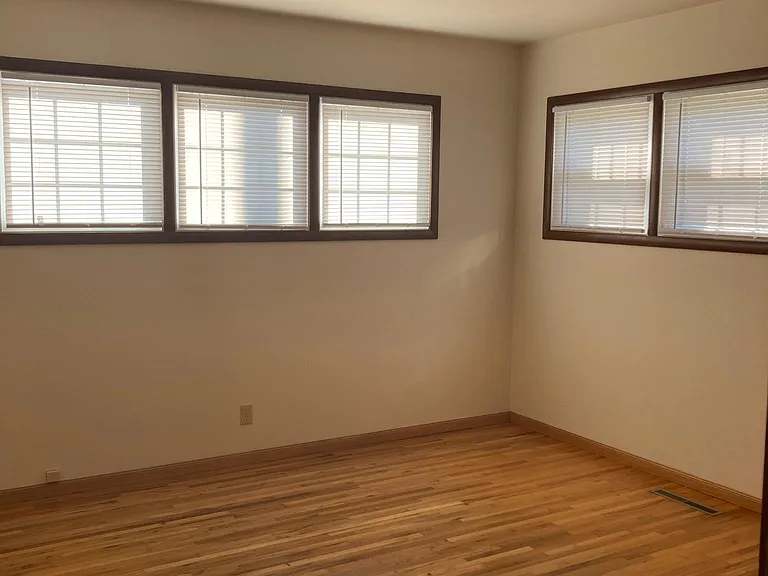 Bedroom with fresh paint and new window coverings.