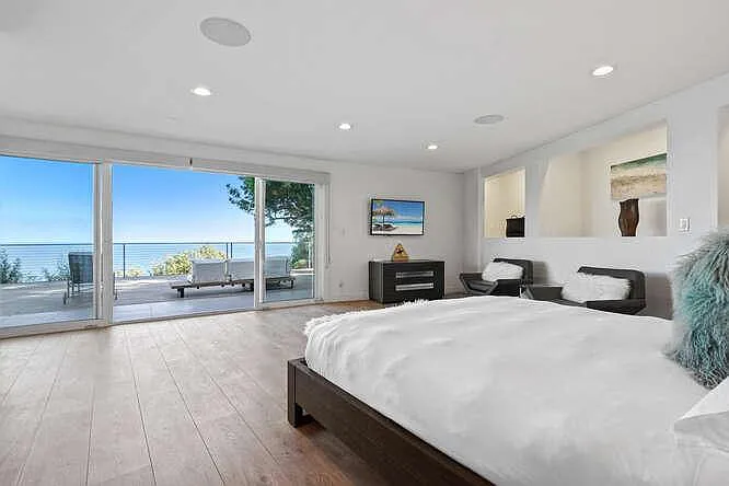 Experience ultimate comfort in our bedroom, with glass doors leading to a serene outdoor lounge.