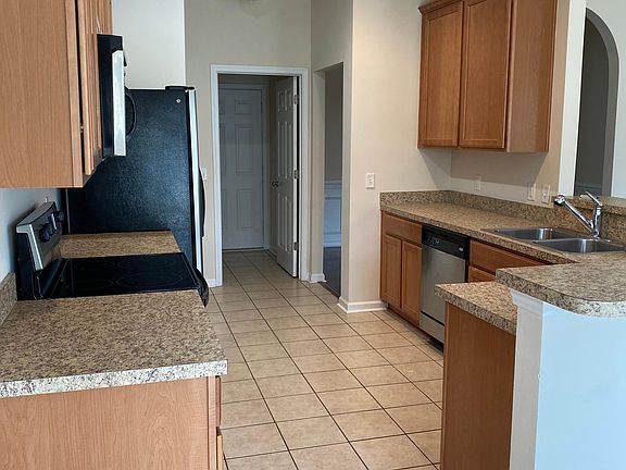 Kitchen has recessed lighting, stainless appliances, abundant cabinets, and pantry