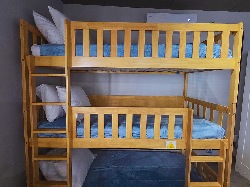 Family-friendly bunk bed for 3 with soft bedding and ample comfort.