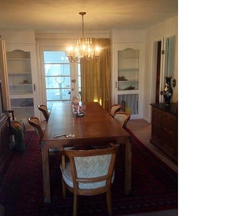 Spacious dining room with built-in hutches with French doors leading to 3 season sun room