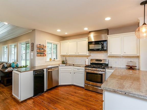 The kitchen has beautiful light cabinets with a gas range, gorgeous subway style backsplash, stainless steel and granite counters.