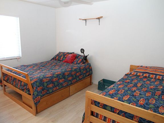 bedroom with twin bed and double bed including storage drawers. Walk in closet and smart tv with roku