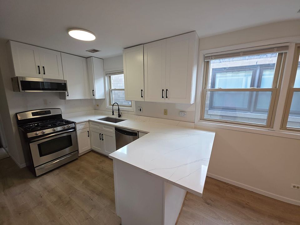 This fully renovated kitchen combines sleek style with everyday functionality. Featuring brand-new white shaker cabinets, elegant quartz-look countertops, and a spacious peninsula, it offers both ample storage and generous prep space. Stainless steel appl