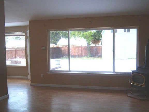 Living room with stove faces the huge back yard.