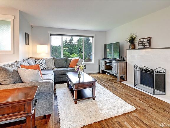 Gorgeous fireplace surround. Home features two wood burning fireplaces. Wood wrapped windows, attractive, modern window coverings.