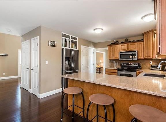 Look at those beautiful Bamboo hardwood floors!!! Built in shelving about refrigerator, gorgeous silestone countertops, tile bac