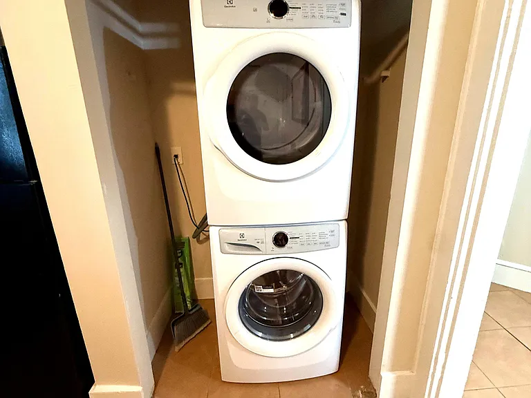 Dedicated laundry nook with a stacked washer and dryer for convenient in-home washing and drying.