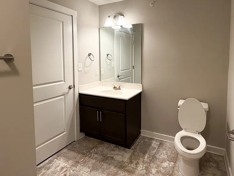 The bathroom features two entry points- one from the bedroom and one from the entry hall.