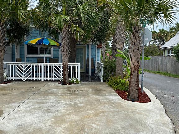 Private patio with outdoor shower under a palm canopy