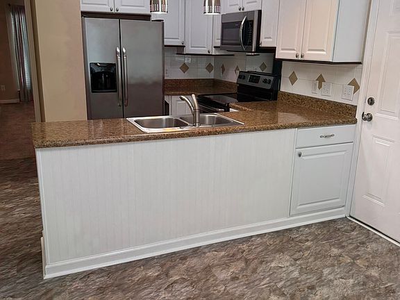 Kitchen featuring refrigerator, dishwasher, disposal, microwave, and stove