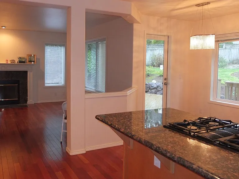 Kitchen with nook area leading to outside yard and overlooking family room