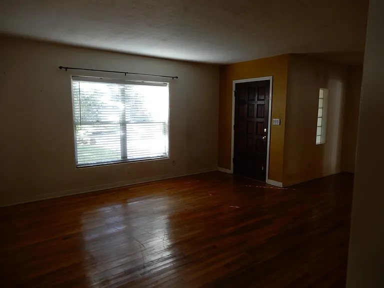 Interior view of front entrance door, east facing double windows in Living room and dining area with glass block window. Beautifully finished solid oak wood floors throughout the entire house except the kitchen, bathrooms and great room.