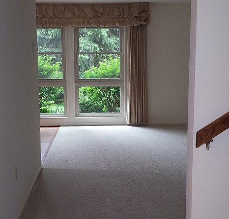 View into livingroom from front door : Floor-ceiling windows add lovely light. Stairs to 2nd floor w