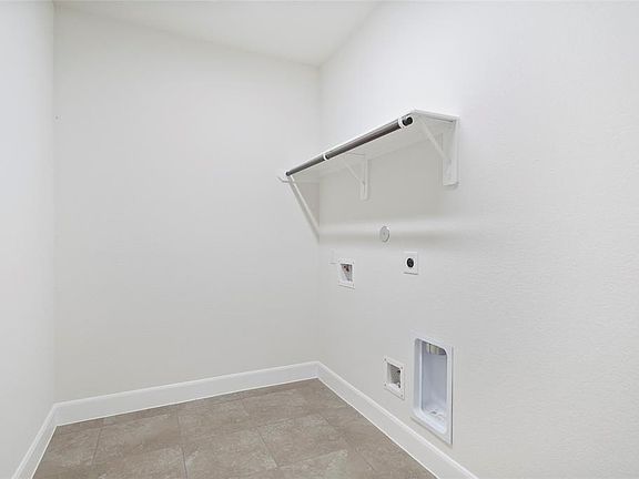 Large Utility room with hanging/storage space and connections.