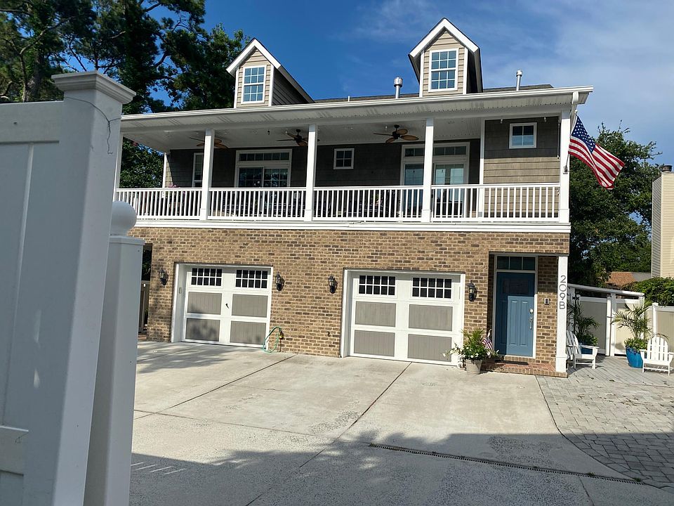 The front door is blue. Two parking spots are provided in addition to the garage.