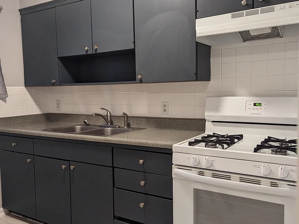 Updated kitchen with sleek dark cabinetry, full size range, and modern finishes that make the space feel sharp, functional, and move in ready.