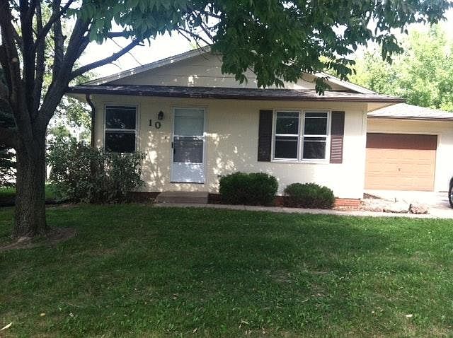 Front of house with single car garage and large parking pad