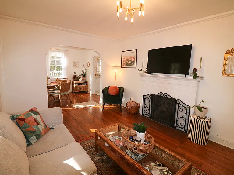 Main living room with original arched entry way into dining room for seamless living space flow