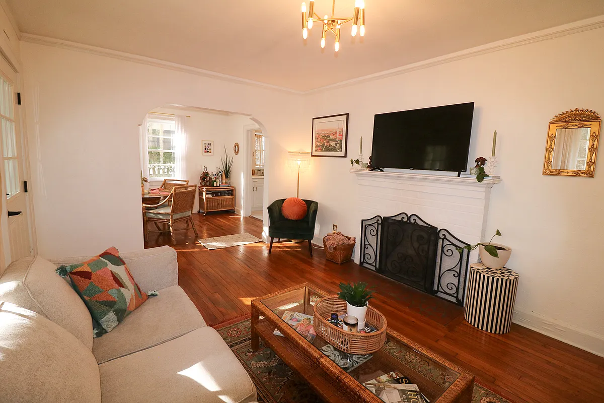Main living room with original arched entry way into dining room for seamless living space flow - 1630 E 51st St
