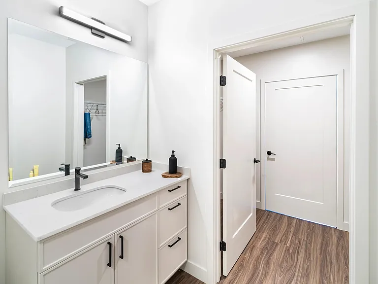 Bright finishes and clean lines bring a modern touch to this bathroom, complete with a spacious vanity offering generous storage below.
