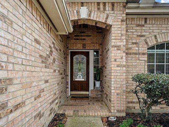 Walking up to the home, we are welcomed by the elegant dark wood front door w/ artful detailed glass panes. The covered porch is accented by a layered keystone centered in the arch & mirrored above the front windows as well.