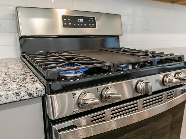 Kitchen stove with oven and sleek granite countertops.