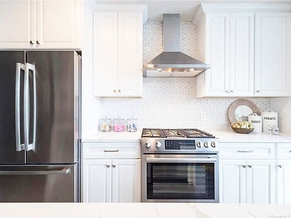 White Cabinets with brushed nickel pulls and Stainless Steel Appliance Package