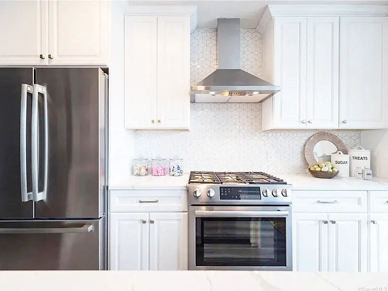 White Cabinets with brushed nickel pulls and Stainless Steel Appliance Package