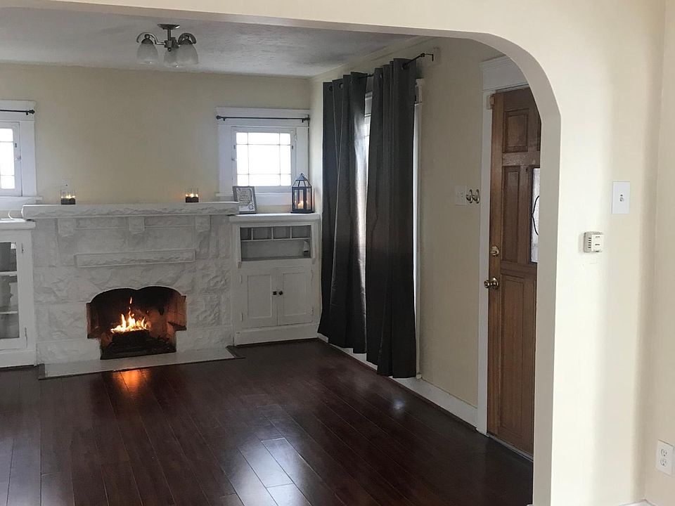 Living room is bright and airy with great lighting. Includes wood burning fireplace and french doors that lead to gated porch. Great for summer/entertaining. Laminate wood flooring.